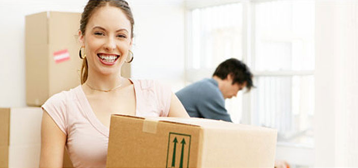 Smiling woman carrying a moving box